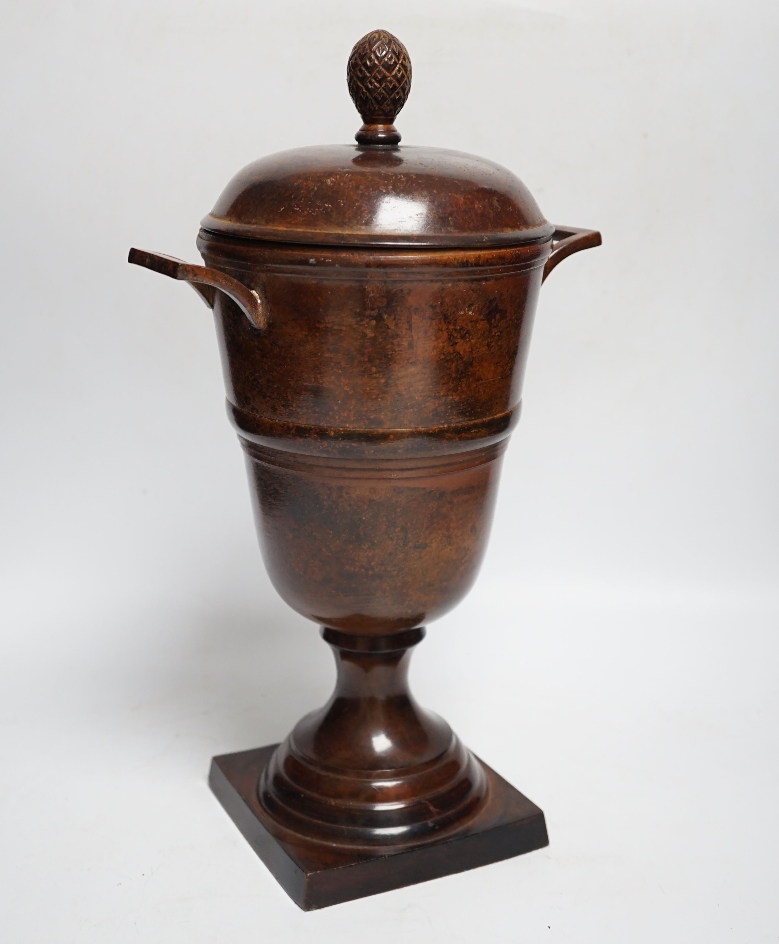 A patinated cast metal two-handled urn and cover with acorn finial, 36.5cm high